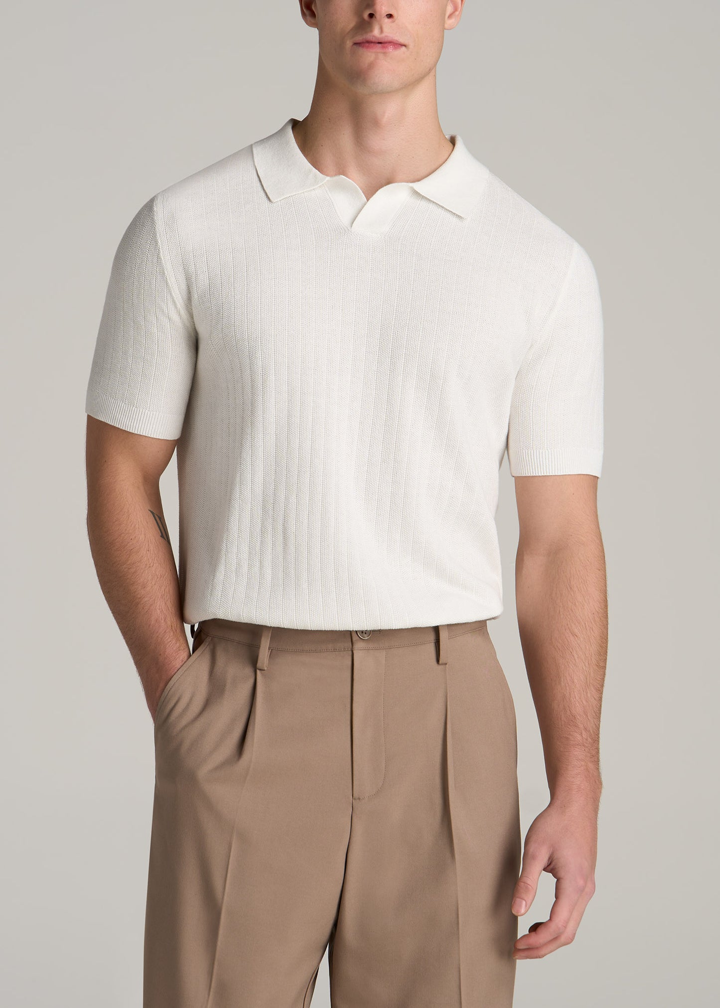 A tall man wearing American Tall's Linen Blend Ribbed Knit Polo Shirt for Tall Men in Ecru