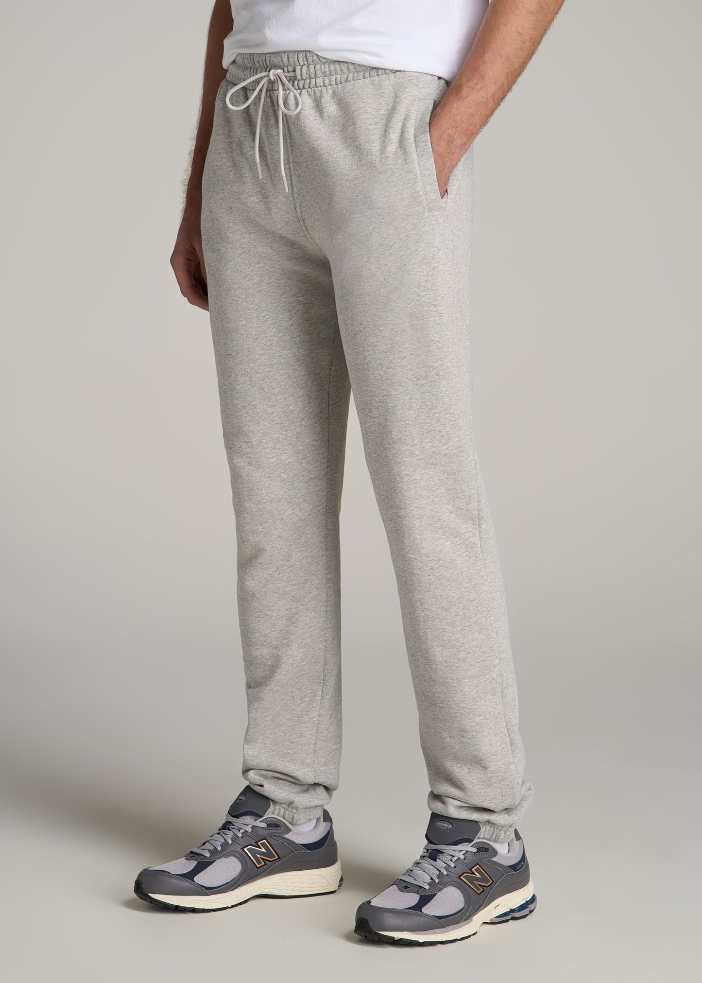 A tall man wearing American Tall's Wearever Fleece Elastic-Bottom Sweatpants for Tall Men in Grey Mix.