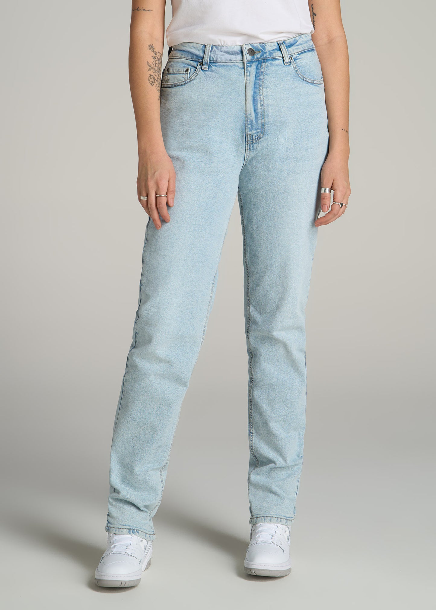 A tall woman wearing American Tall's Emma High-Rise Relaxed Tapered Jean in Vintage Light Indigo.