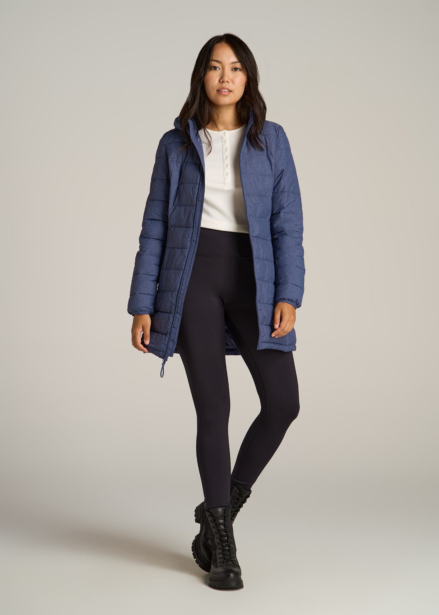A tall woman wearing American Tall's Packable Puffer Jacket for Tall Women in Blue Space Dye.