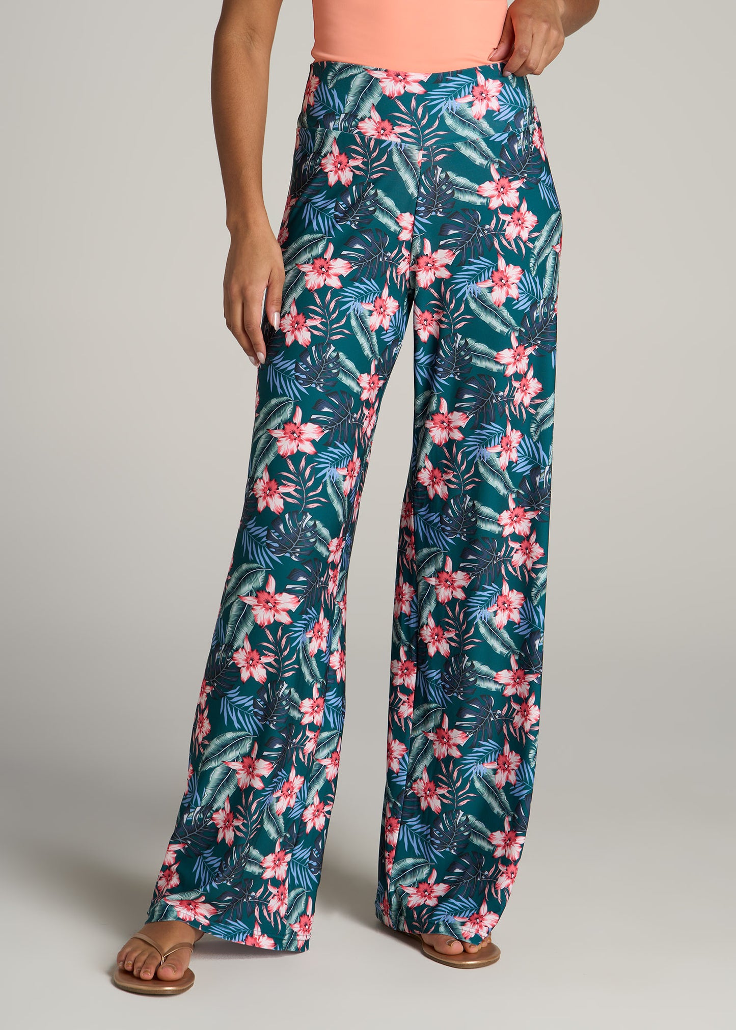 A tall woman wearing American Tall's Pull On Breezy Wide Leg Pants for Tall Women in Green Tropical Floral Print.