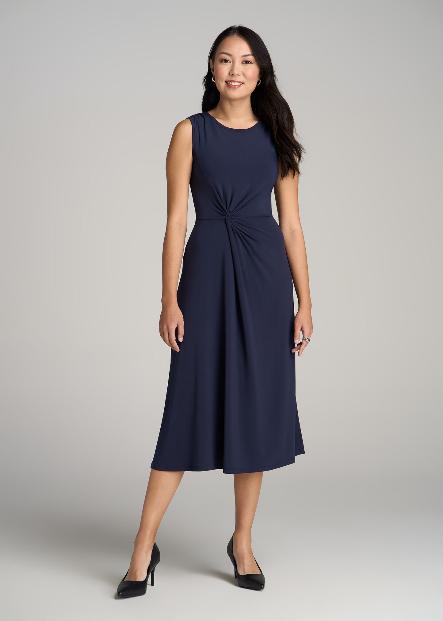 A tall woman wearing American Tall's Sleeveless Knot Front Dress for Tall Women in Navy