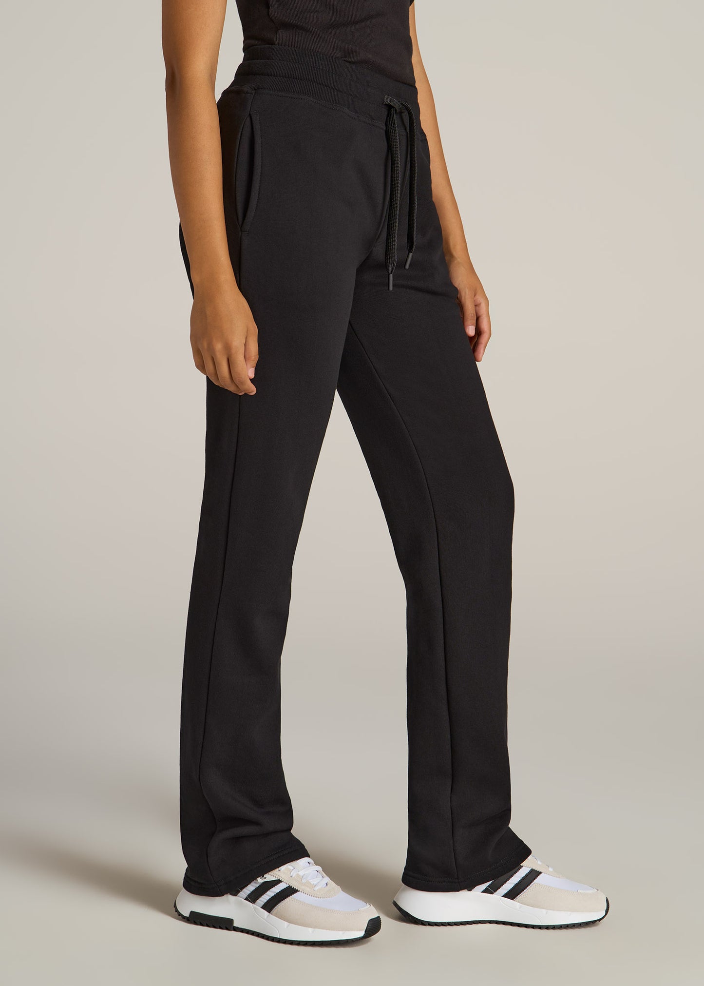 A tall woman wearing American Tall's Wearever Fleece Open-Bottom Sweatpants in the color black.