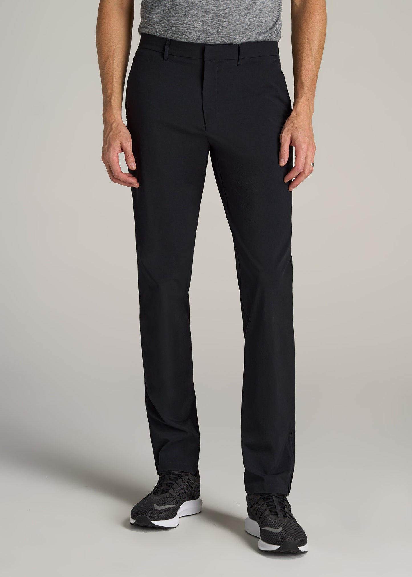 A tall man wearing American Tall's Performance Performance Tapered-Fit Chino Pants in Black.