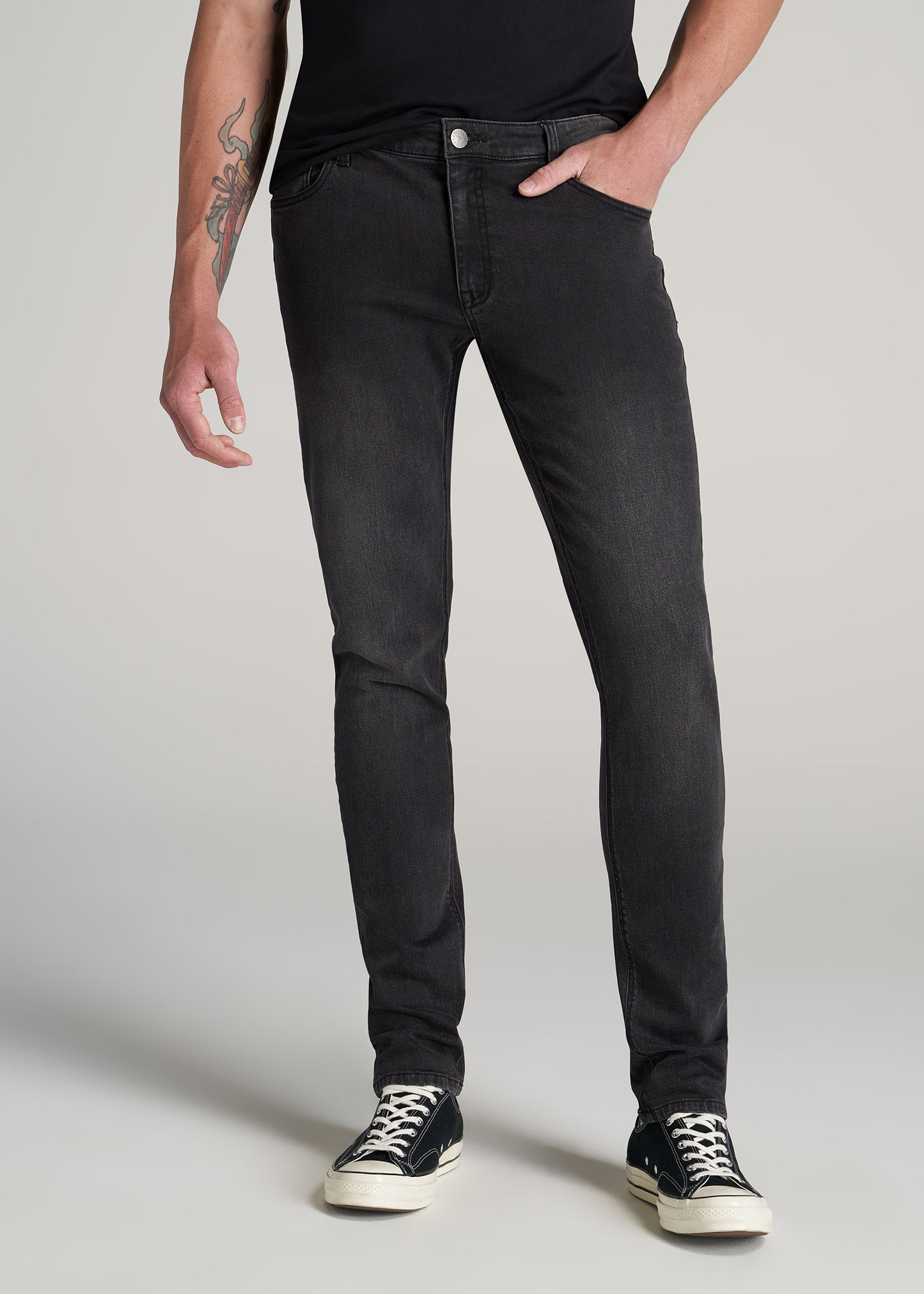 A tall man wearing American Tall's Travis Skinny Jeans for Tall Men in Dark Smoke.