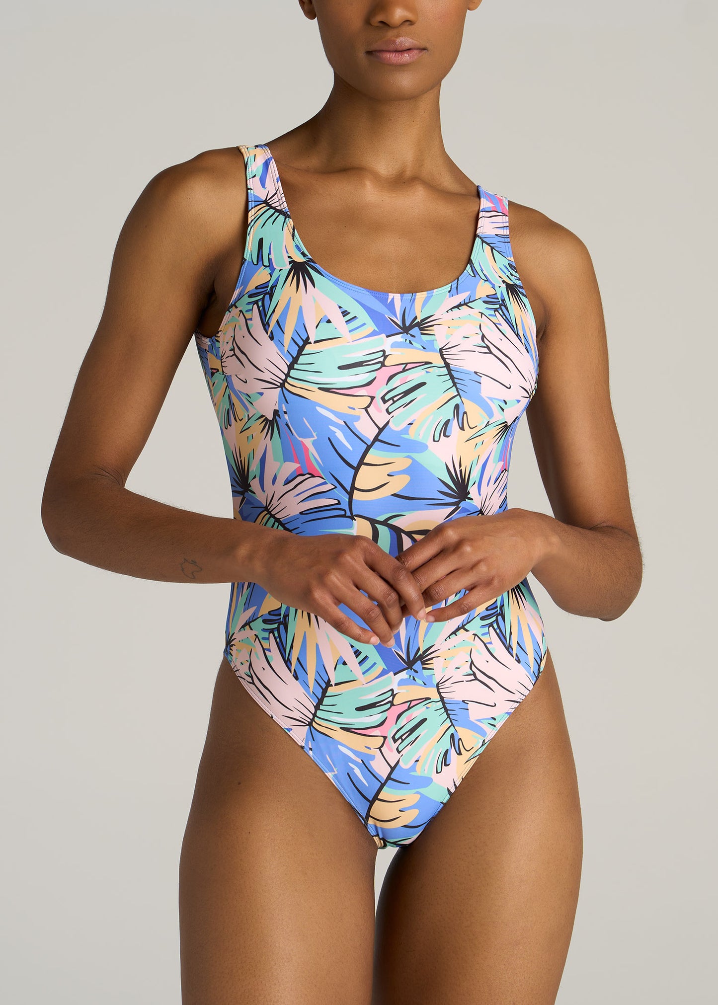 Front view of a tall woman wearing American Tall's Women's Tall One-Piece Swimsuit in Abstract Tropical.