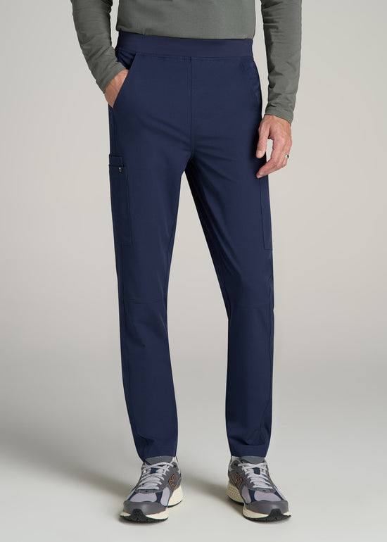 A tall man wearing American Tall's Cargo Scrub Pants in the color Patriot Blue.
