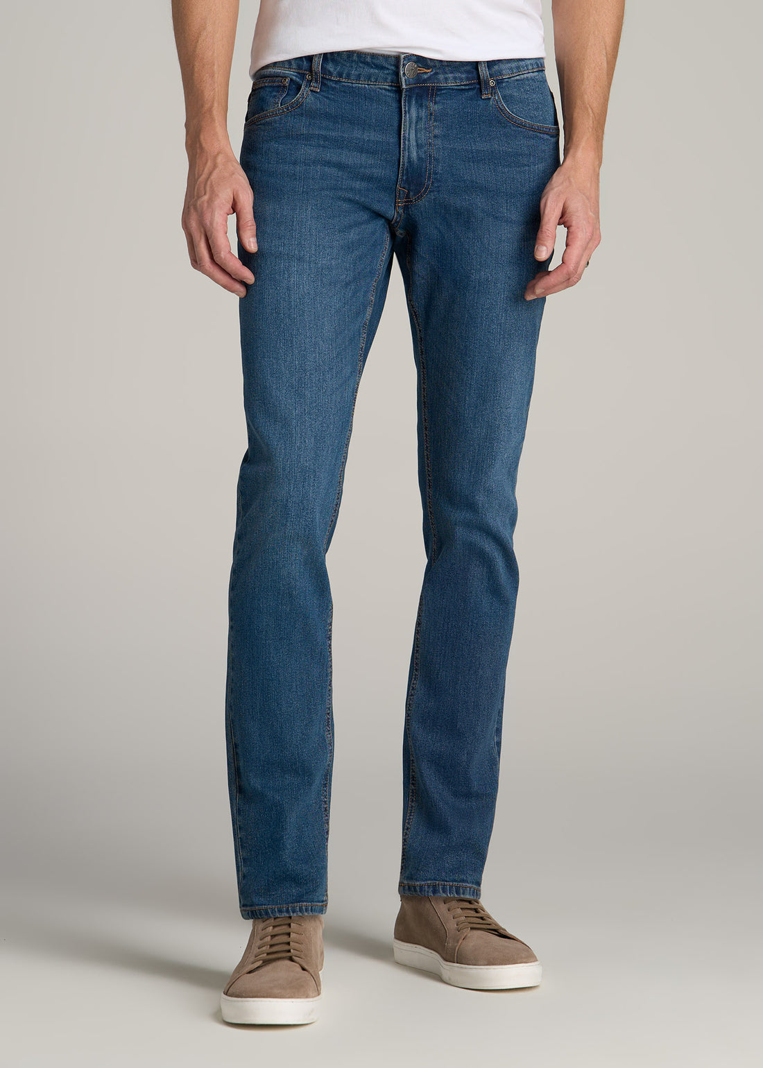 Tall man wearing American Tall's Carman Tapered Jeans in the color Worn Blue.
