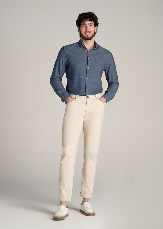 A tall man wearing American Tall's Chambray Button-Down Shirt for Tall Men in the color Medium Chambray.