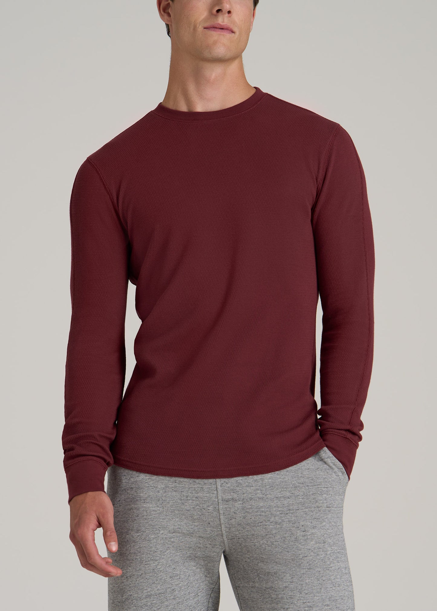 A tall man wearing American Tall's Double Honeycomb Thermal Crewneck Extra-Long Top in Red Ochre