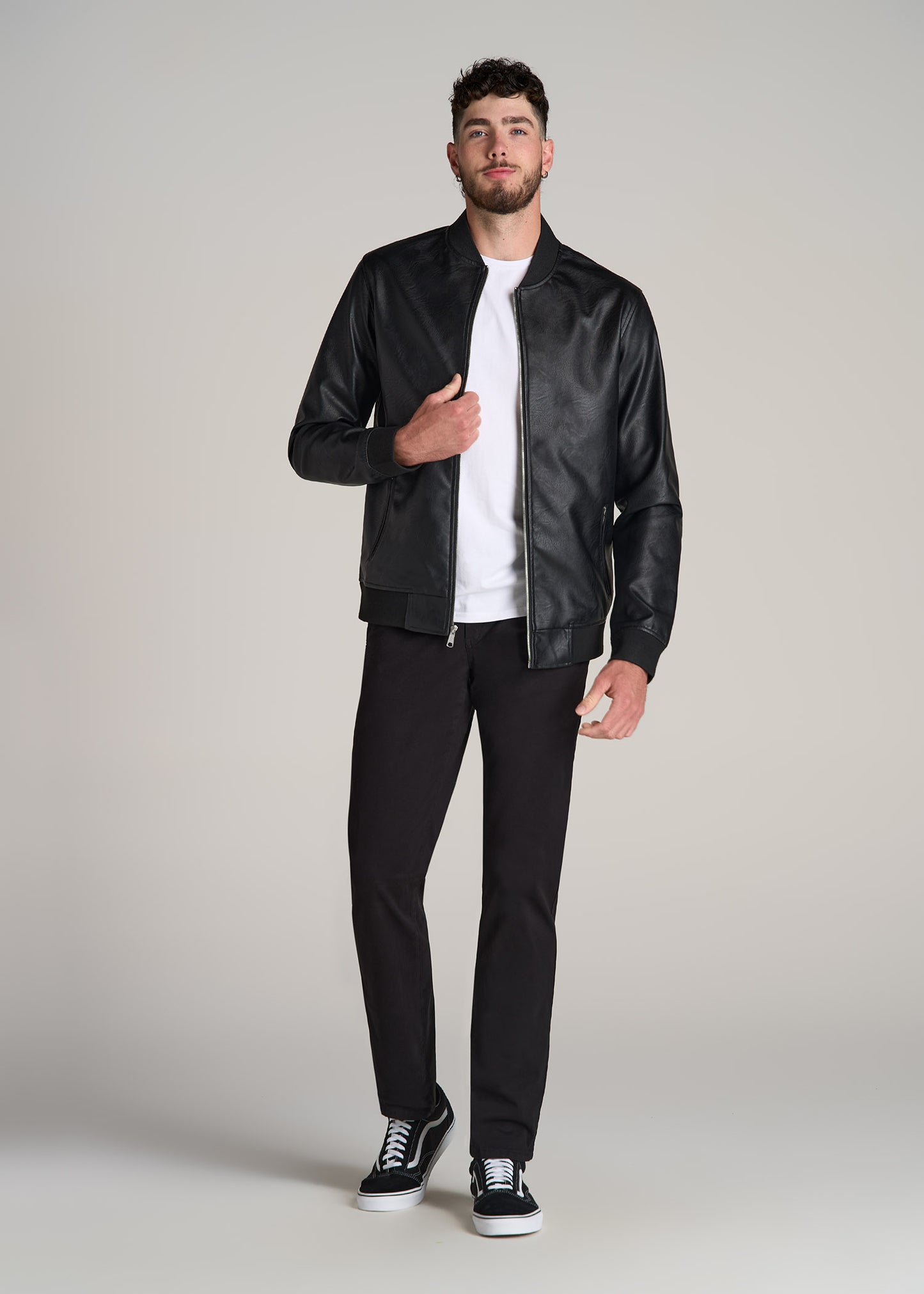 A tall man wearing American Tall's Faux Leather Bomber Jacket in the color black.