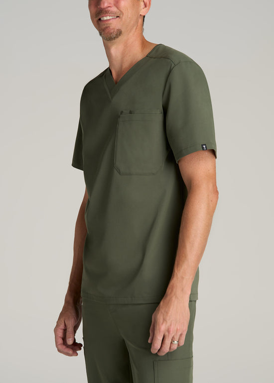 A tall man wearing American Tall's Short-Sleeve V-Neck Scrub Top in the color Clover Green.