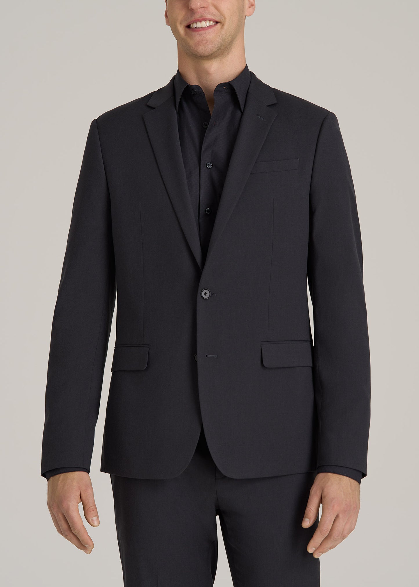 A tall man wearing American Tall's Suit Jacket for Tall Men in Mid Grey