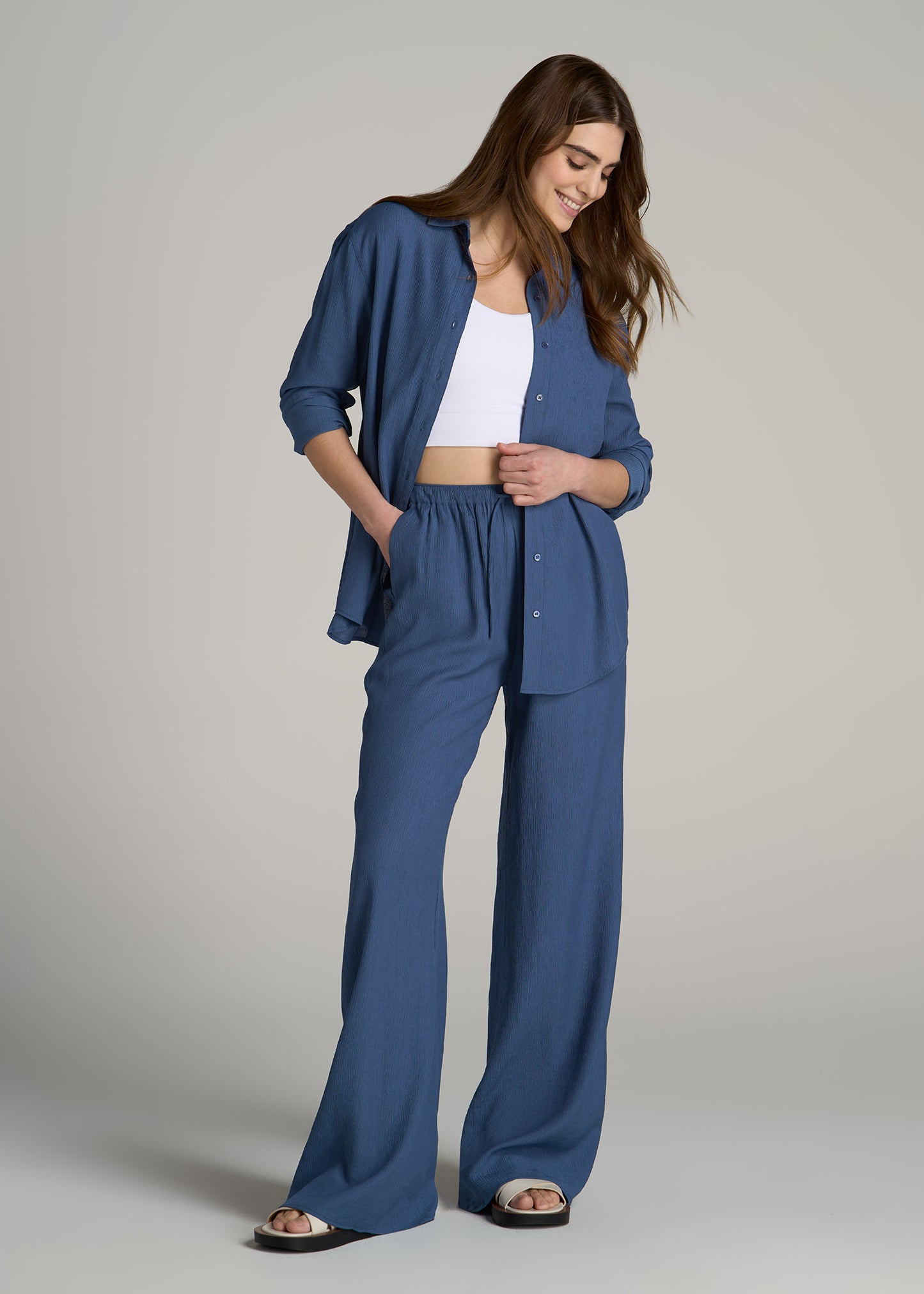 A tall woman wearing Crinkle Pull-on Wide-leg Pants for Tall Women in Steel Blue from American Tall