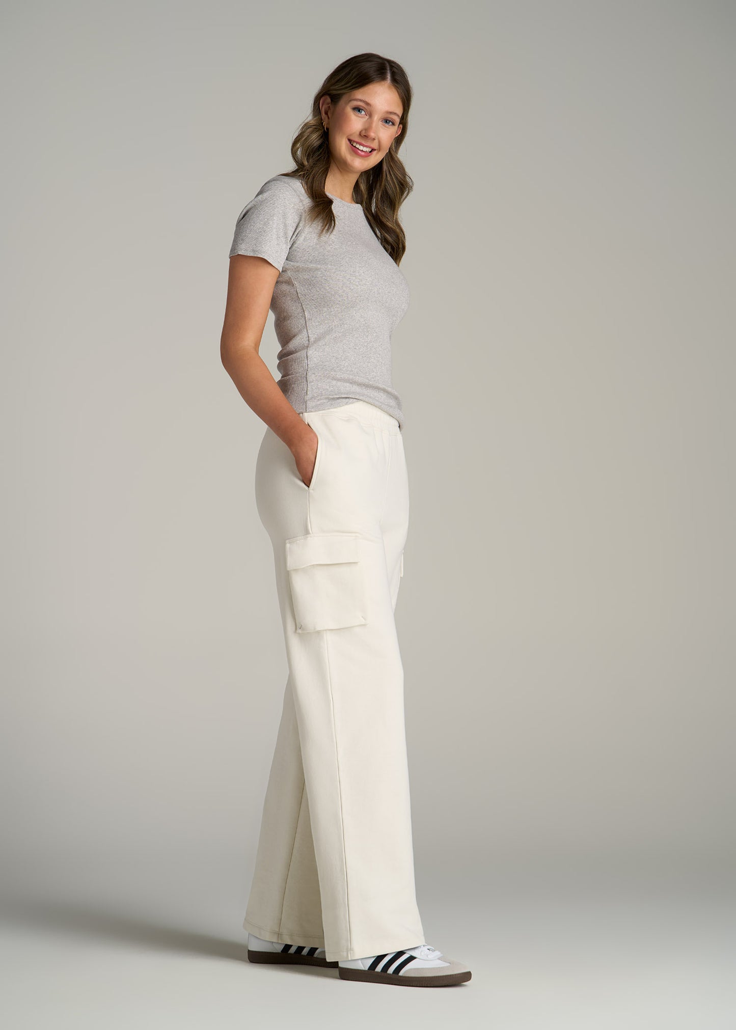 A tall woman wearing Wearever French Terry Wide Leg Cargo Women's Tall Sweatpants in White Alyssum from American Tall