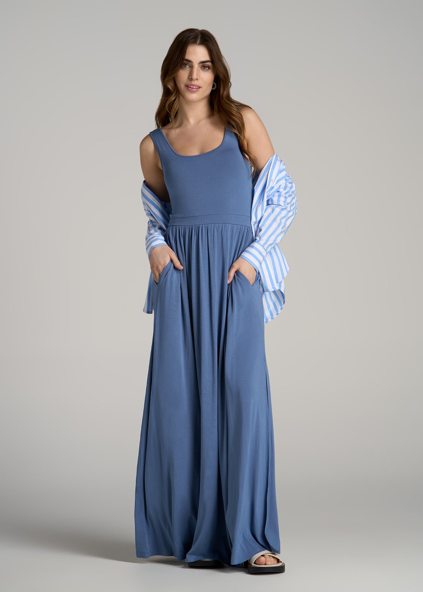 A tall woman wearing American Tall's  Jersey Tank Maxi Dress with Pockets for Tall Women in Steel Blue.