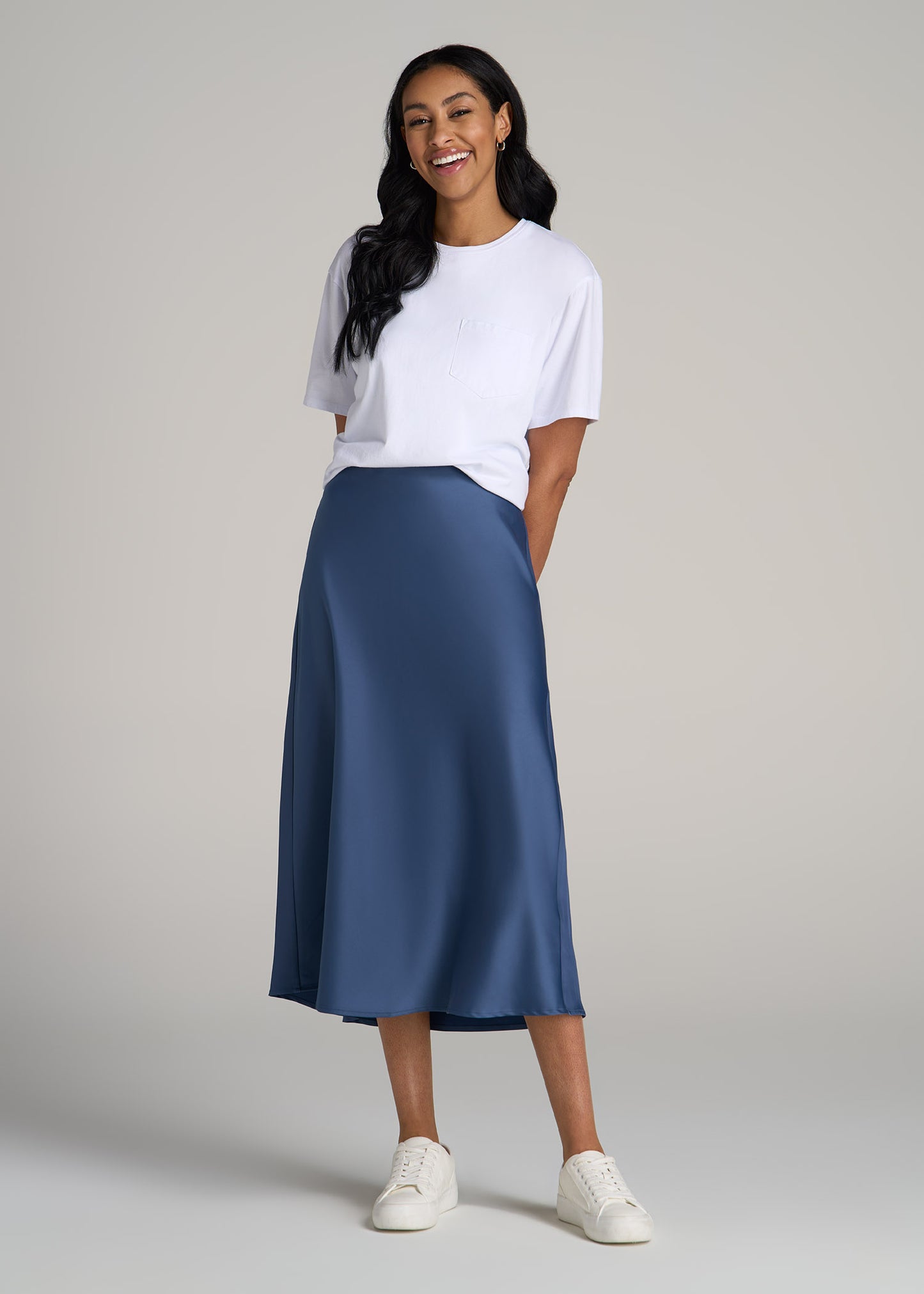 A tall woman wearing American Tall's Pull-On Satin Midi Skirt in Steel Blue and Boxy Short Sleeve T-Shirt in Bright White.