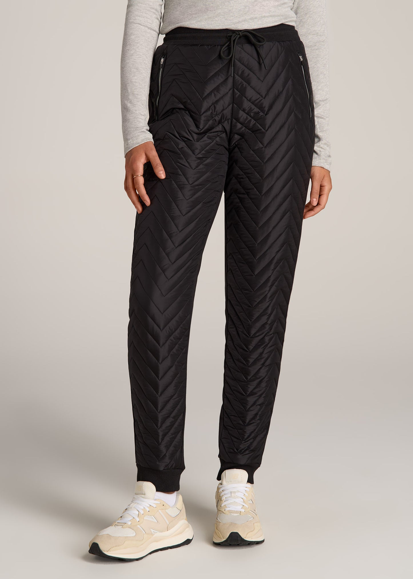 A tall woman wearing American Tall's Quilted Extra-Long Joggers in the color Black.