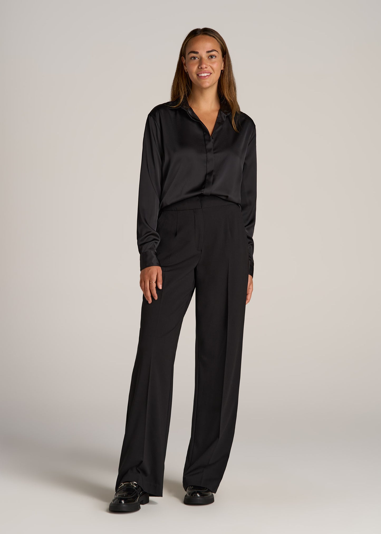 A tall woman wearing American Tall's Relaxed Button-Up Blouse in the color Black.