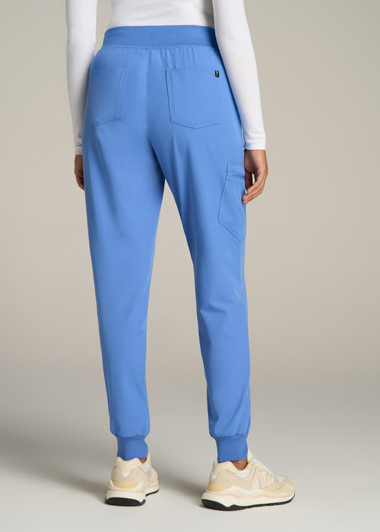 A tall woman wearing American Tall's Scrub Joggers in the color Deep Sky Blue.