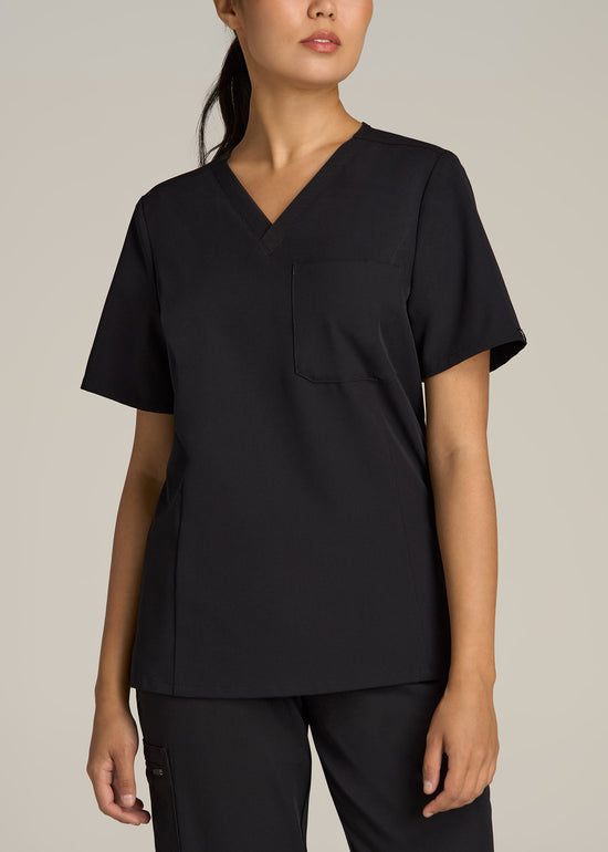 A tall woman wearing American Tall's Short Short Sleeve V-Neck Scrub Top in the color Black.