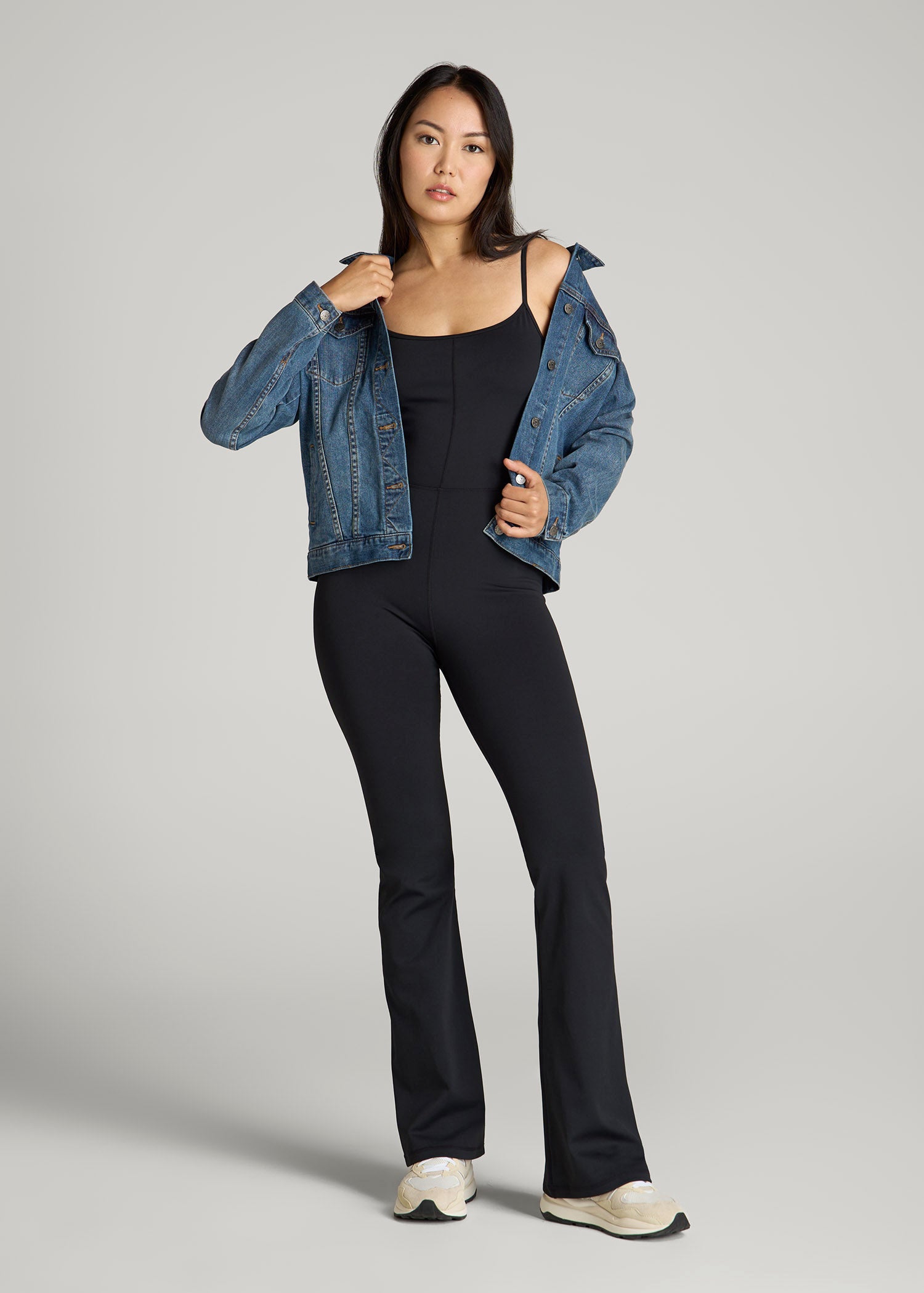 Tall woman wearing the American Tall Spaghetti Strap Flare Jumpsuit in Black with adjustable straps, styled for date night