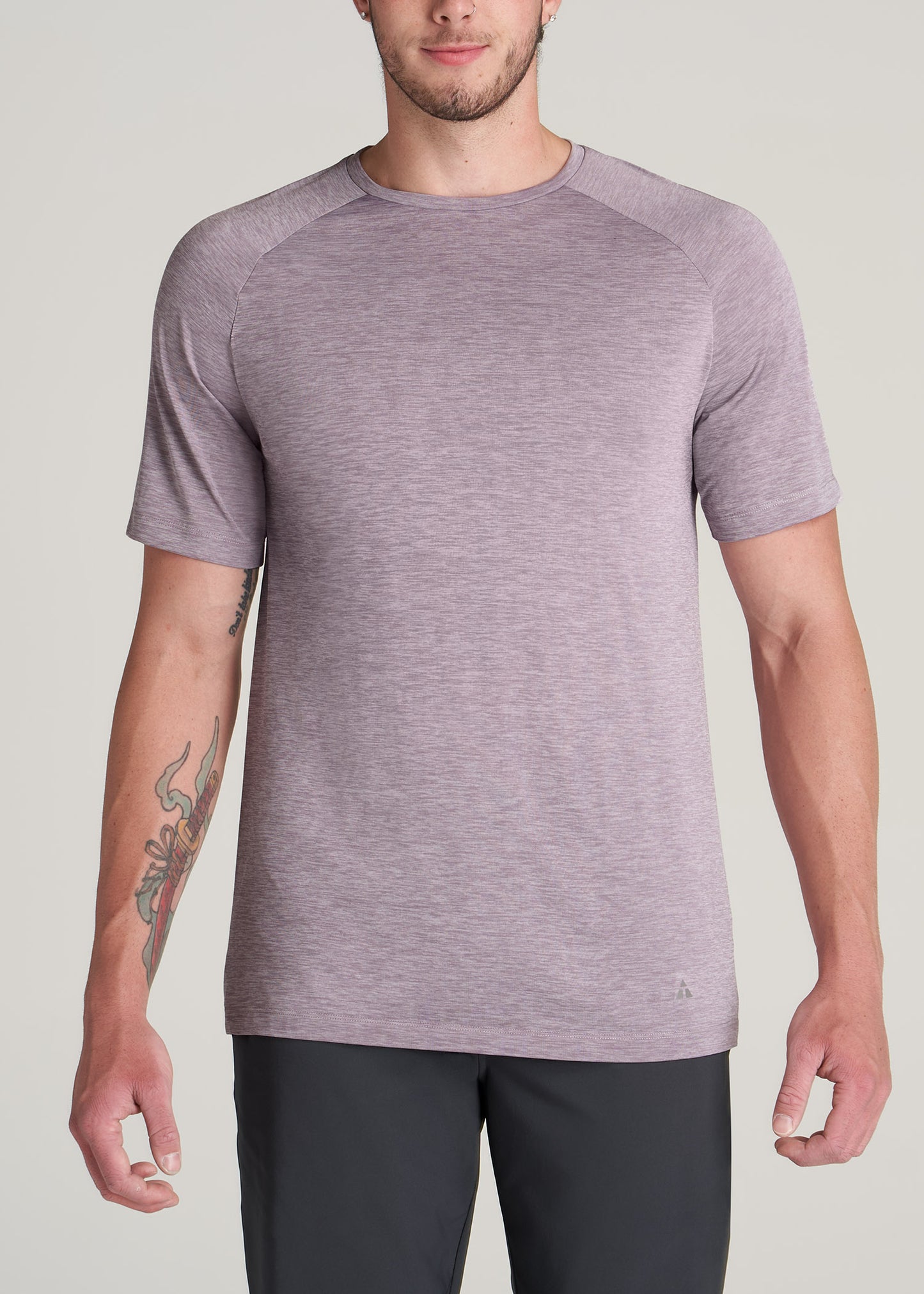 A tall man wearing American Tall's A.T. Performance MODERN-FIT Raglan Short sleeve Tee for Tall Men in Lavender Mix.