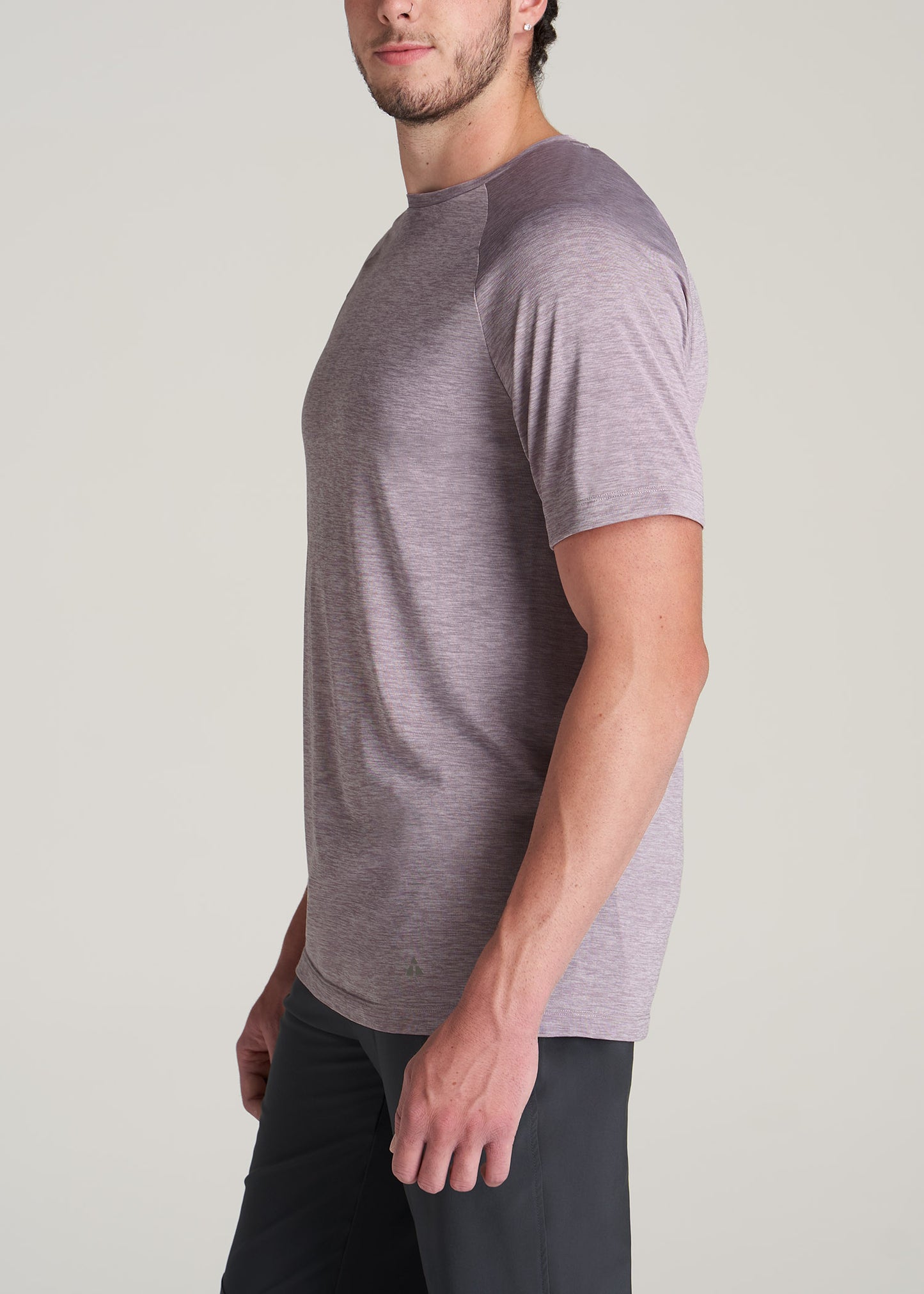 Side view of a tall man wearing an athletic wear t-shirt in lavender.