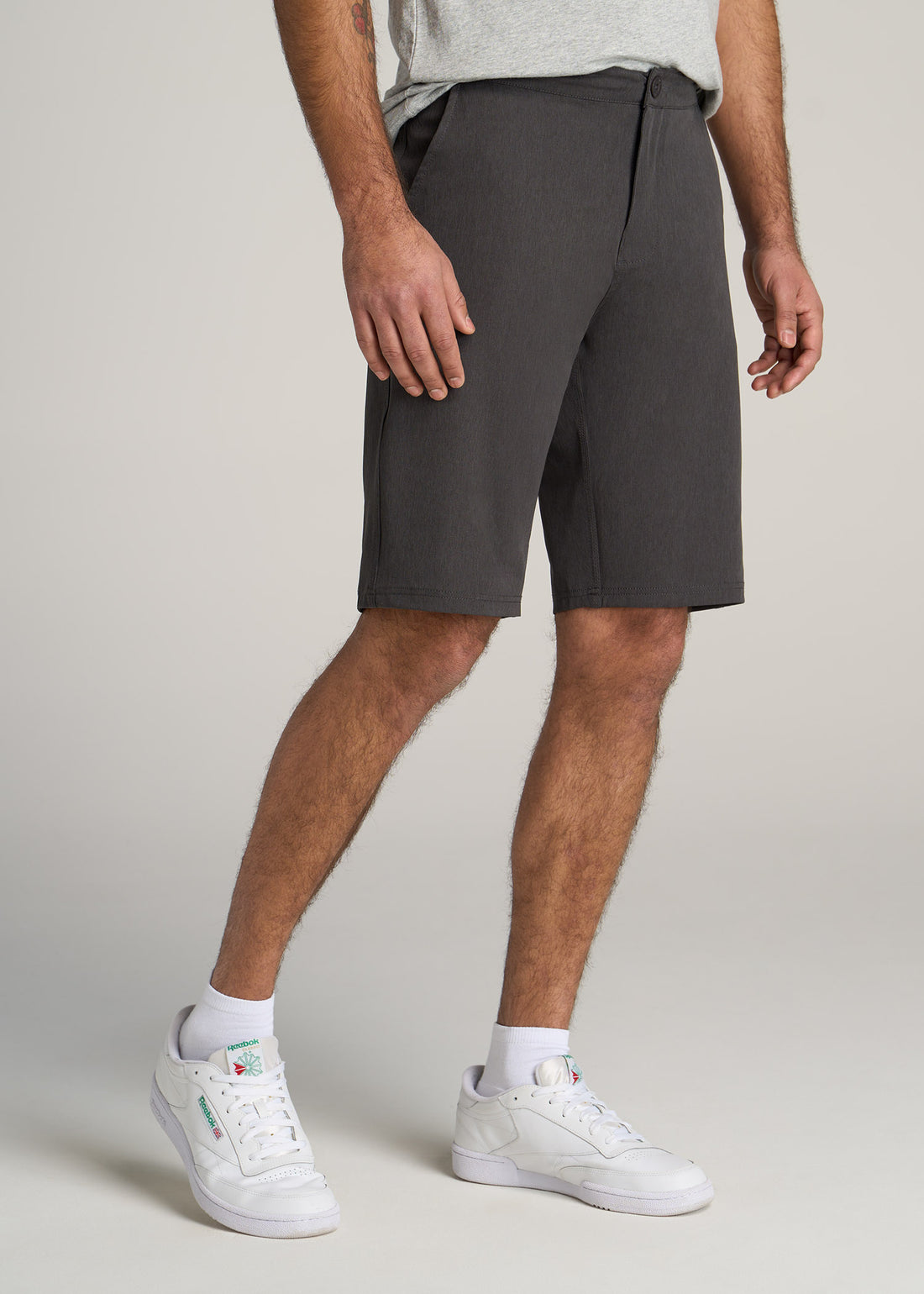 Tall man wearing oceanside shorts in a slate grey color.