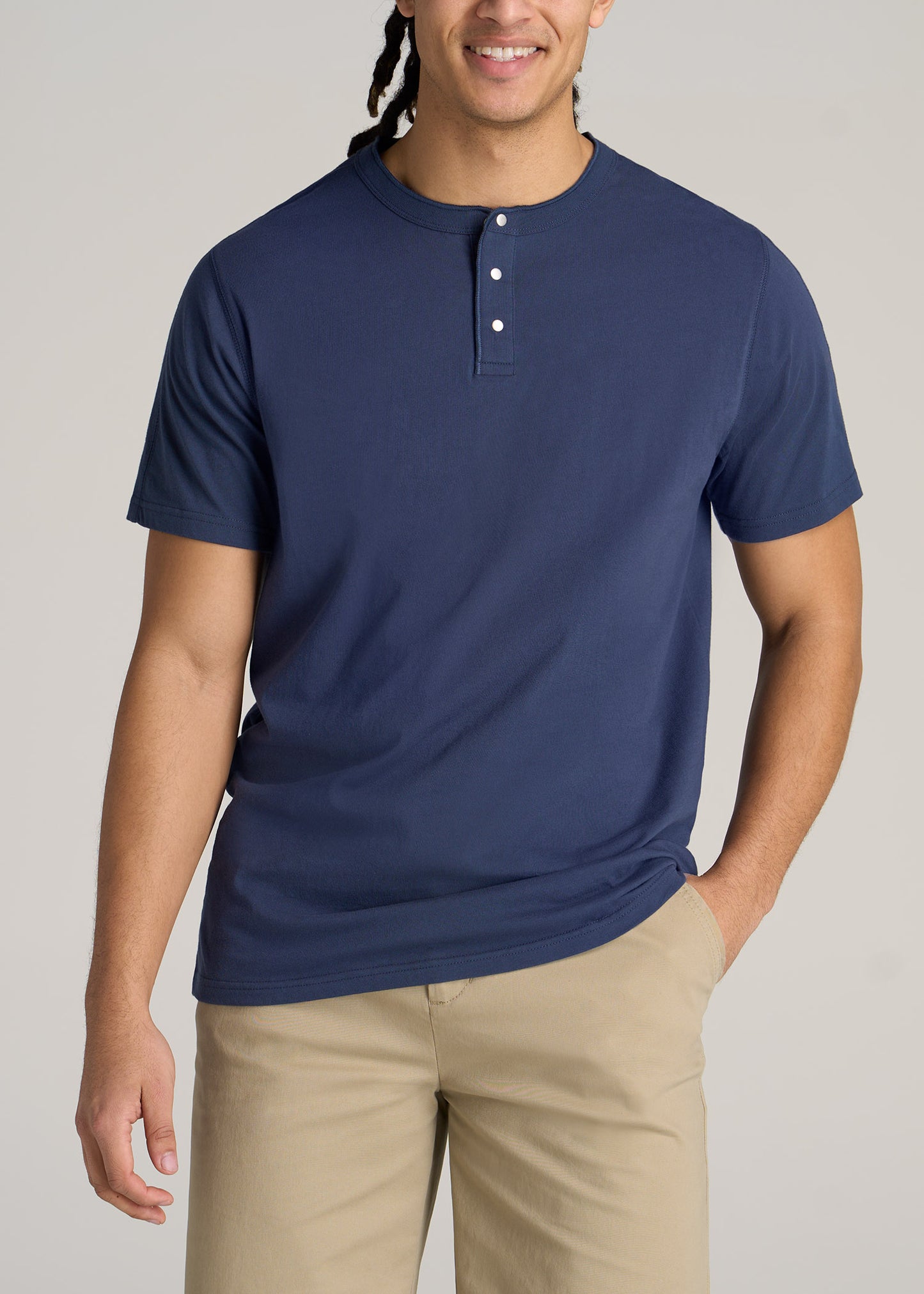 A tall man wearing a regular-fit jersey henley t-shirt in blue.