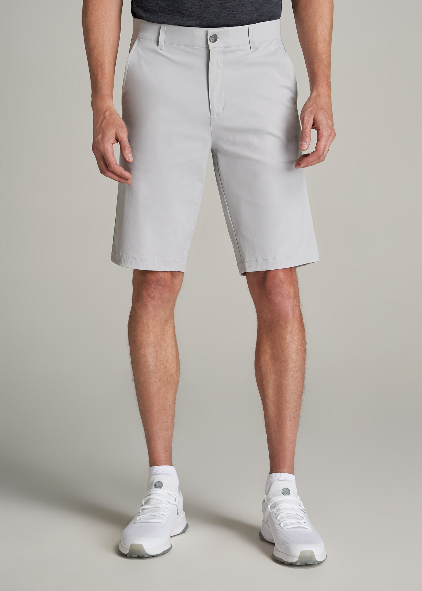 A tall man wearing American Tall's Traveler Chino Shorts in Light Grey.