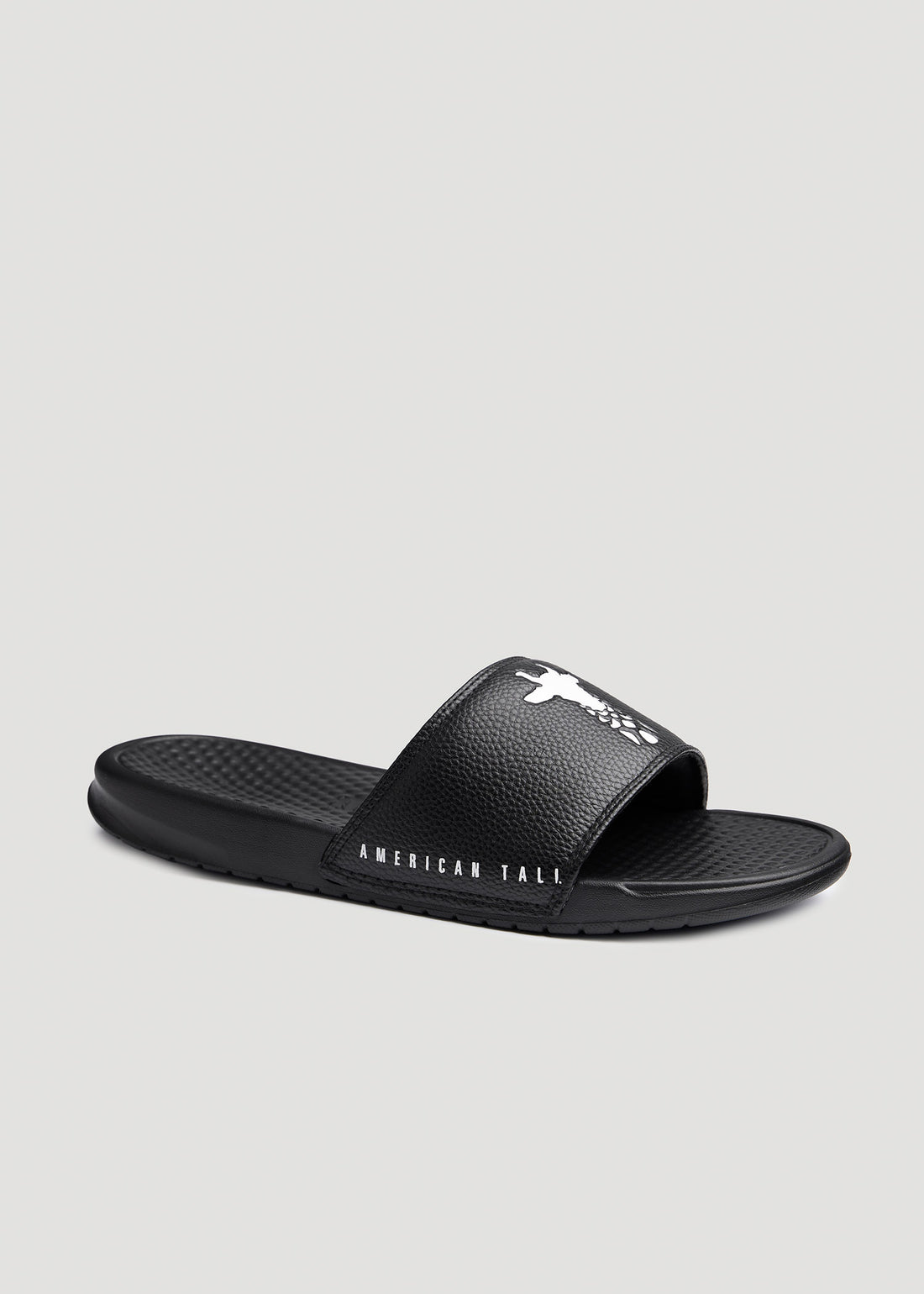 Side view of American Tall branded black slides with the white giraffe logo on the top and brand name on the side.