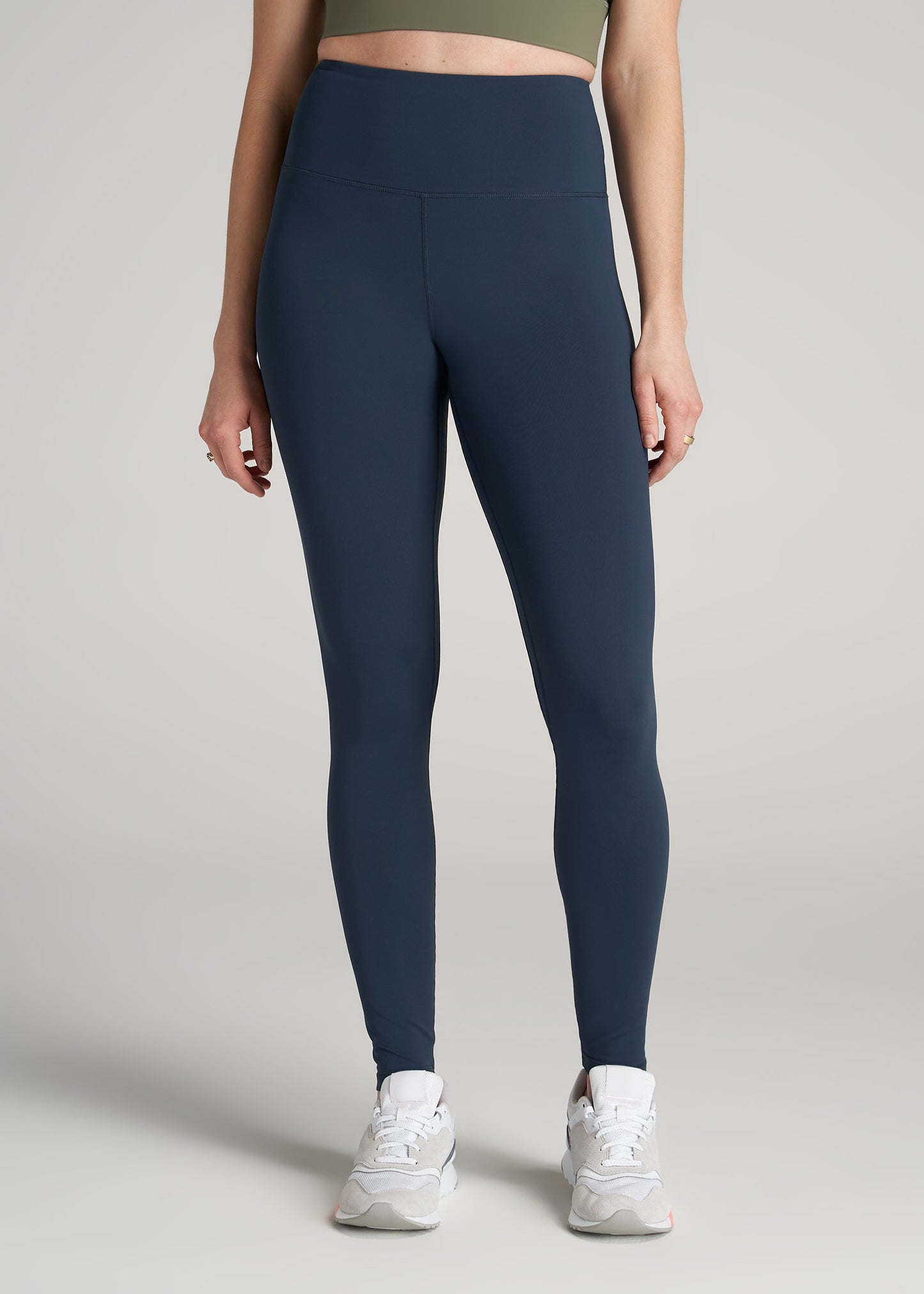 A tall woman wearing American Tall's Balance High-Rise Leggings in bright navy.
