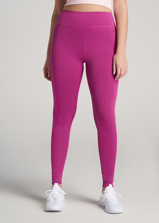 A tall woman wearing American Tall's Pocket Legging in pink orchid.