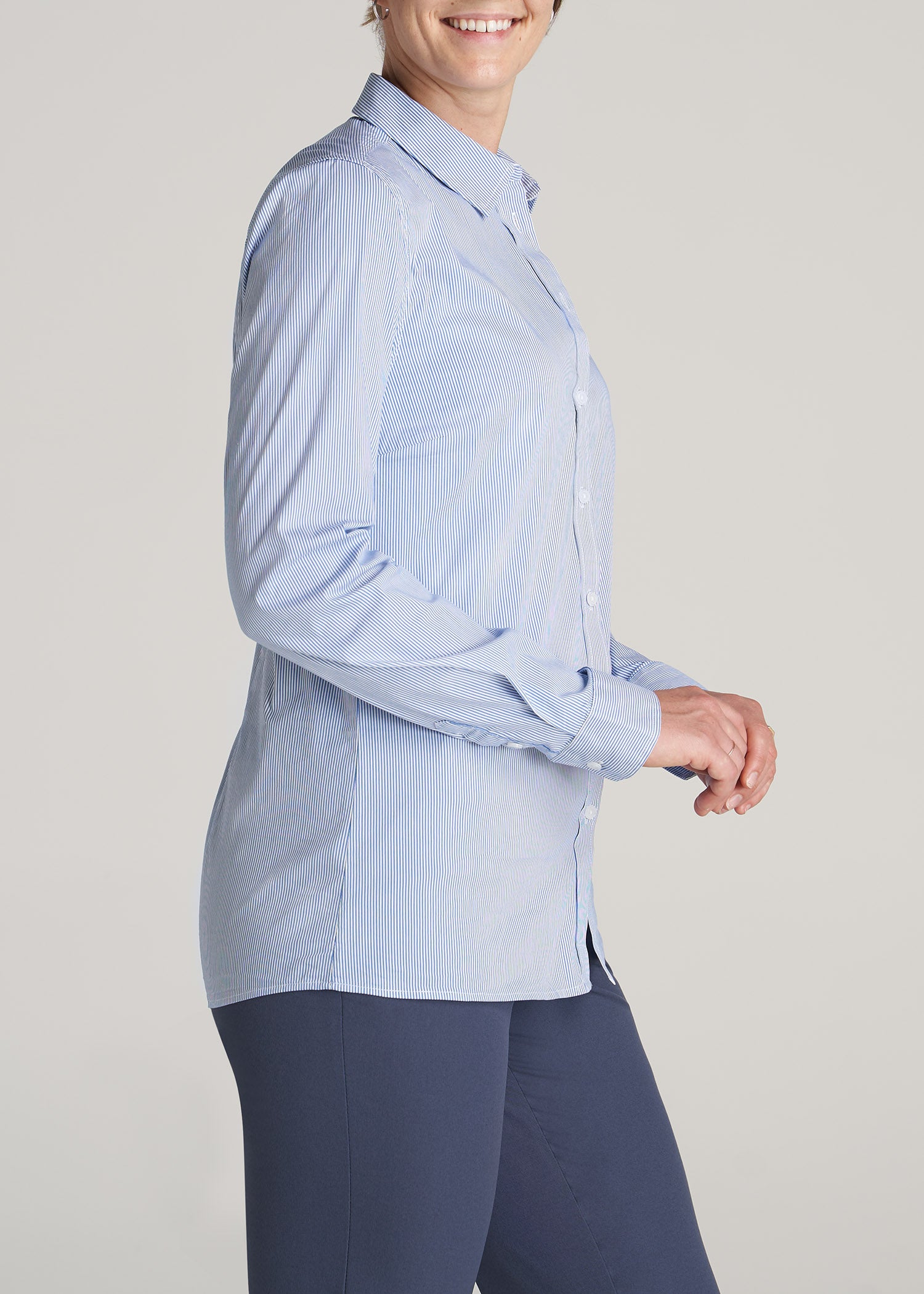 A tall woman wearing American Tall's Button-Up Dress Shirt in Blue Banker Stripe.