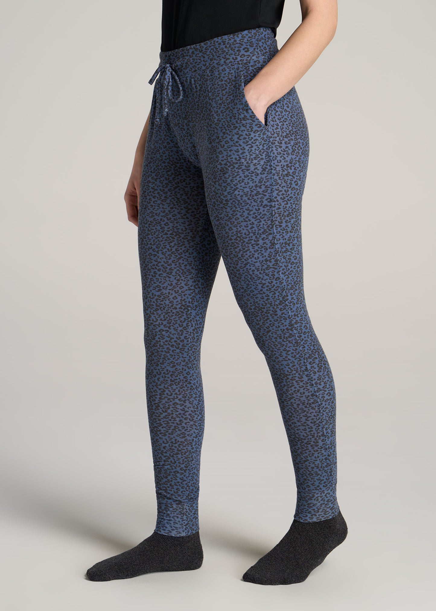 A tall woman wearing American Tall's Cozy Lounge Joggers for Tall Women in the color Navy Leopard Print.