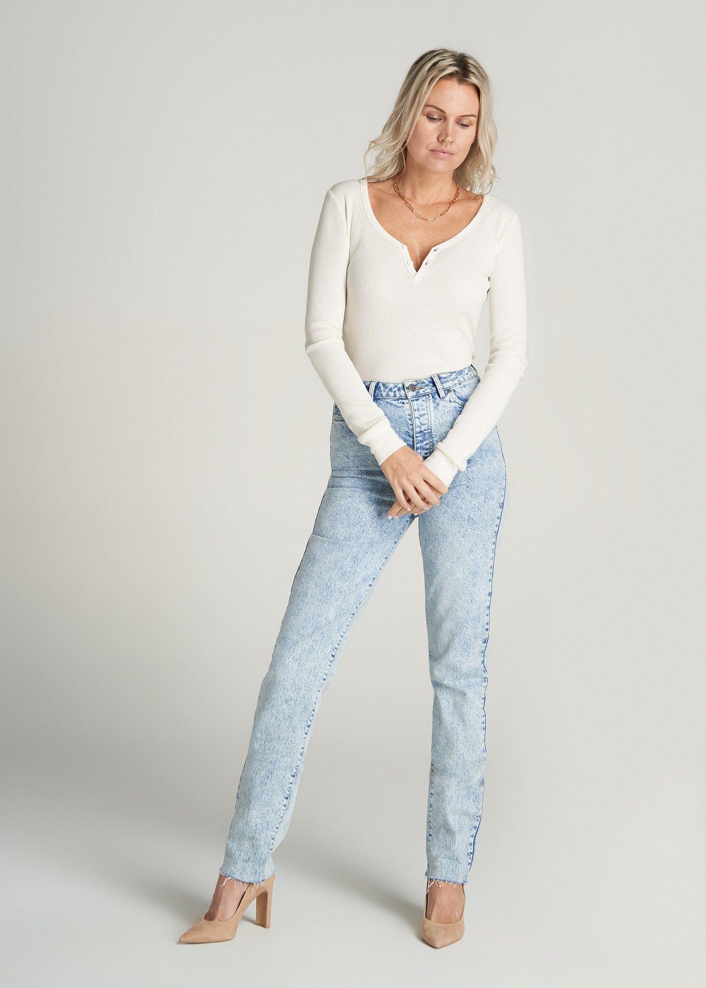 A tall woman wearing American Tall's Lola Ultra High-Rise Slim Jeans in Light Stonewashed Blue.
