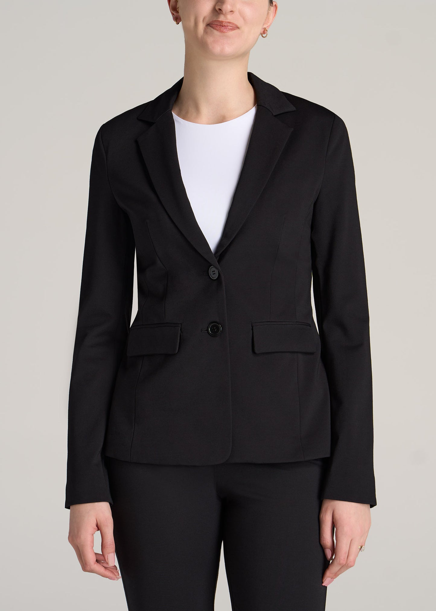 A tall woman wearing American Tall's Two-Button Blazer in the color black.