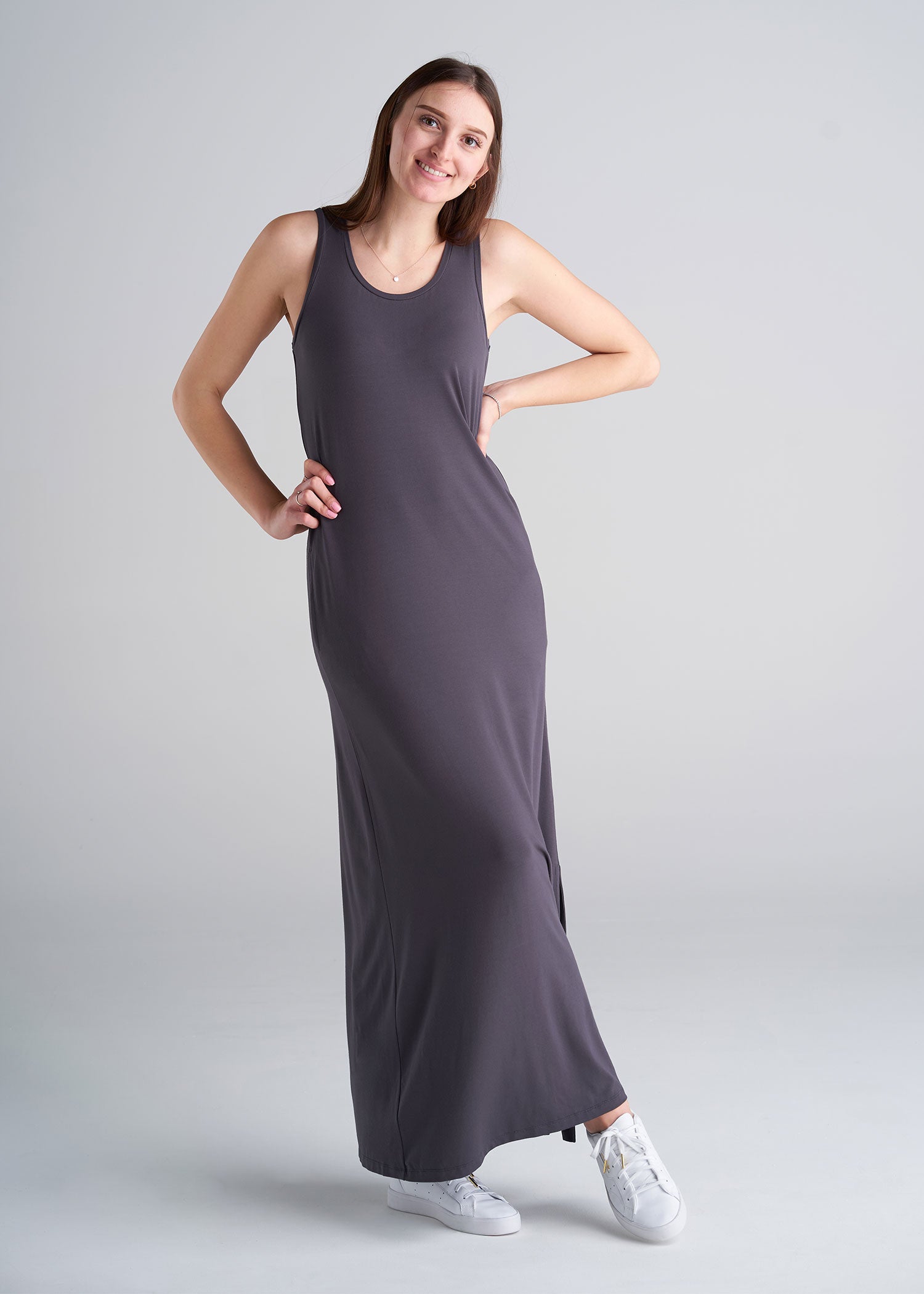 A tall woman wearing a jersey maxi dress in the color dark charcoal.
